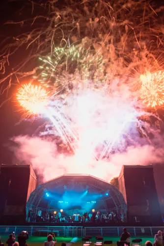 Orcheestra on outdoor stage with fireworks